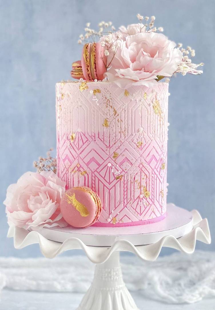 Pink art-deco geometric cake with peony and macarons