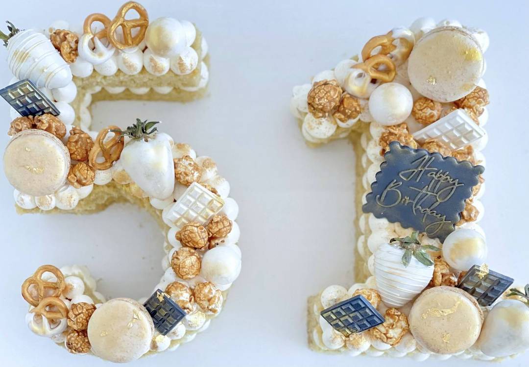 Number 51 ivory and gold cake with macarons and gilded treats